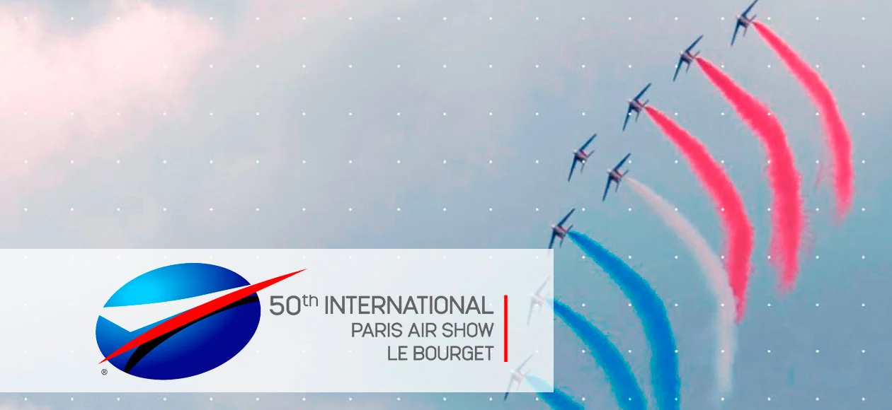 An air show with jets performing an aerial display, releasing red, white, and blue smoke trails, celebrating aviation innovation.