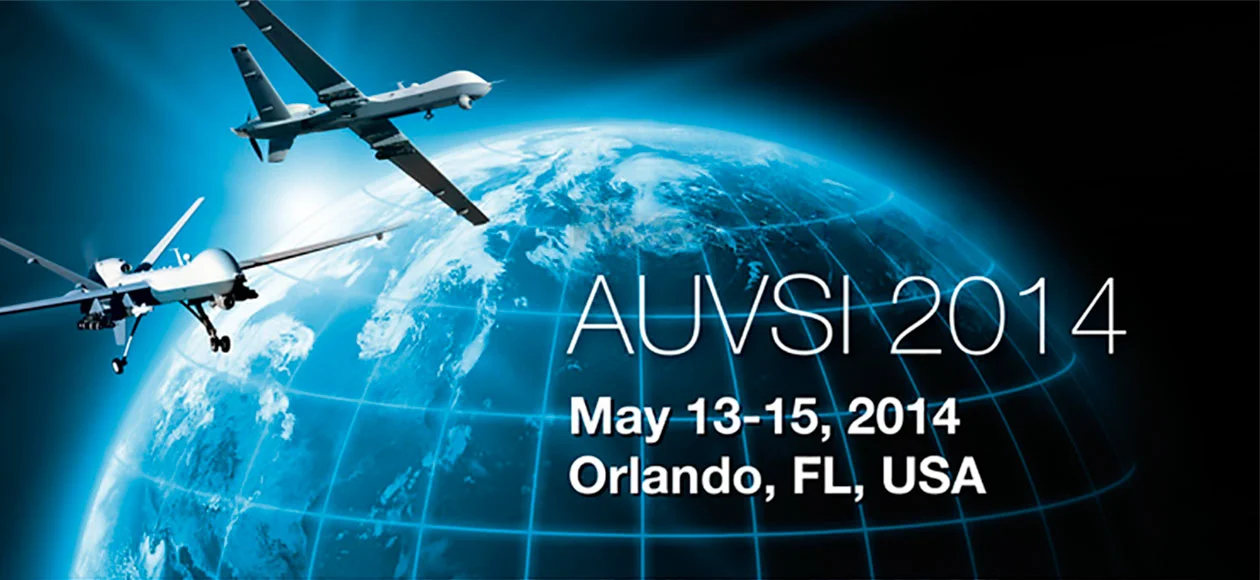 Promotional banner for AUVSI 2014 in Orlando, Florida, featuring drones flying over a globe, emphasizing global unmanned systems.