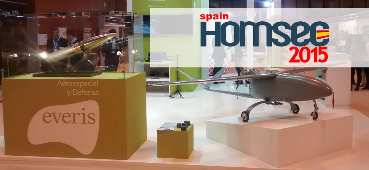 A booth at HOMSEC 2015 showcases aerospace and defense technology, featuring a UAV and missile models by Everis.
