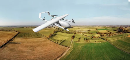 Agricultural drone flying over patchwork fields in rural landscape for precision farming.