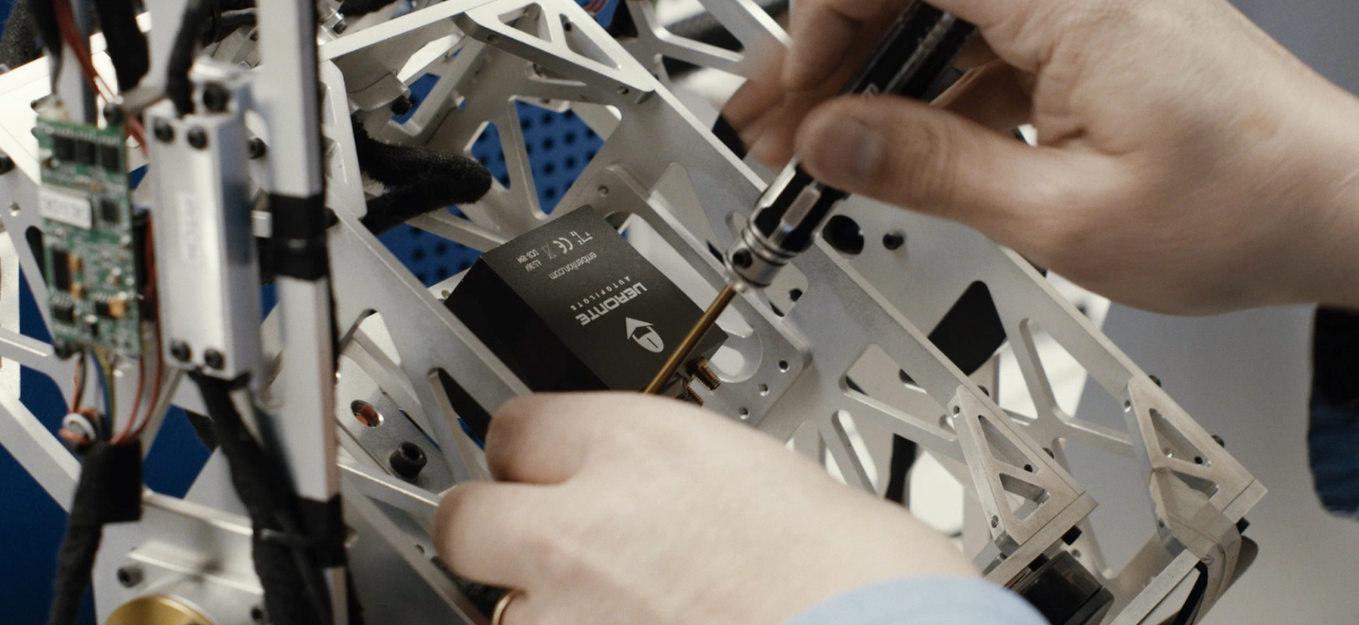 Engineer installing a memory card in a UAV during quality control inspection.